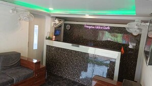A reception area with a marble counter, a clock, and a sign for Arnespruna Hotels & Resorts. - Arnnapurna Hotels & Resorts (Jajapur)