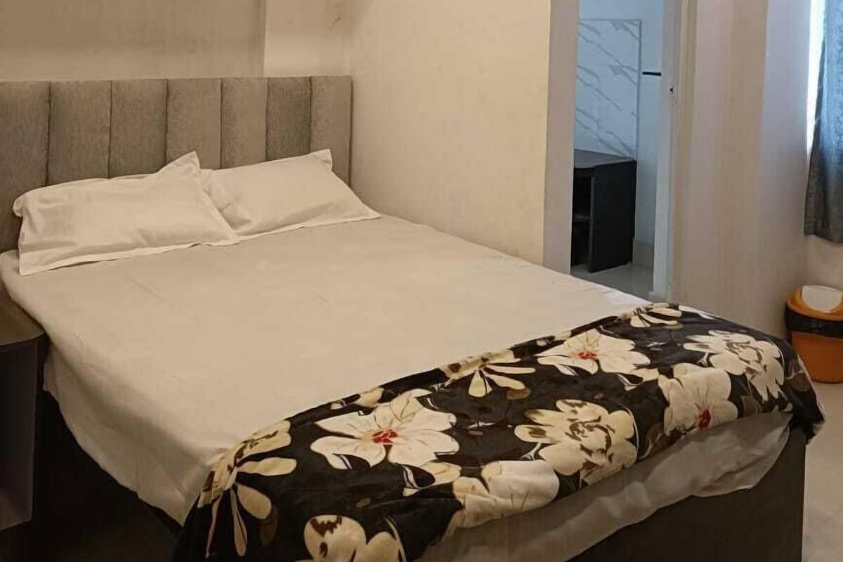 Ein modernes Schlafzimmer mit Bett, Deckenventilator und einer Tür zu einem anderen Raum.