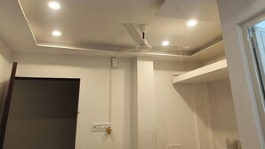 A room with a white ceiling, recessed lighting, a ceiling fan, and a door on the left. - Arnnapurna Hotels & Resorts (Jajapur)