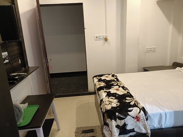 A bedroom with a bed, a desk, and a wardrobe. - Arnnapurna Hotels & Resorts (Jajapur)