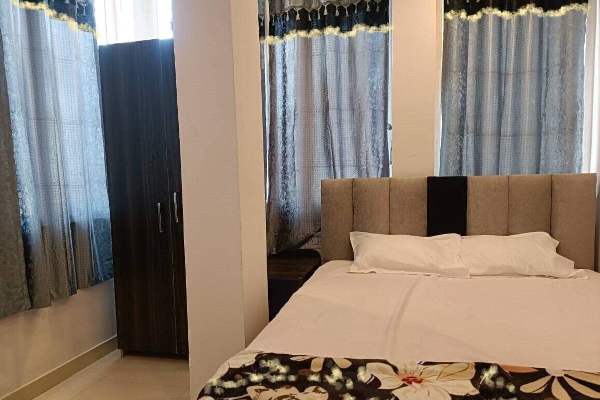 Ein Schlafzimmer mit einem Bett, Vorhängen und einem Kleiderschrank.