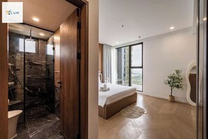 A modern bathroom with a glass shower enclosure and a separate toilet area. - Lumiere Riverside Residences Luxury (Ho Chi Minh City)