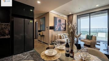 Departamento panorámico, 2 habitaciones, balcón, vista a la ciudad | Área de sala de estar | Televisión de pantalla plana de 65 pulgadas con canales por cable