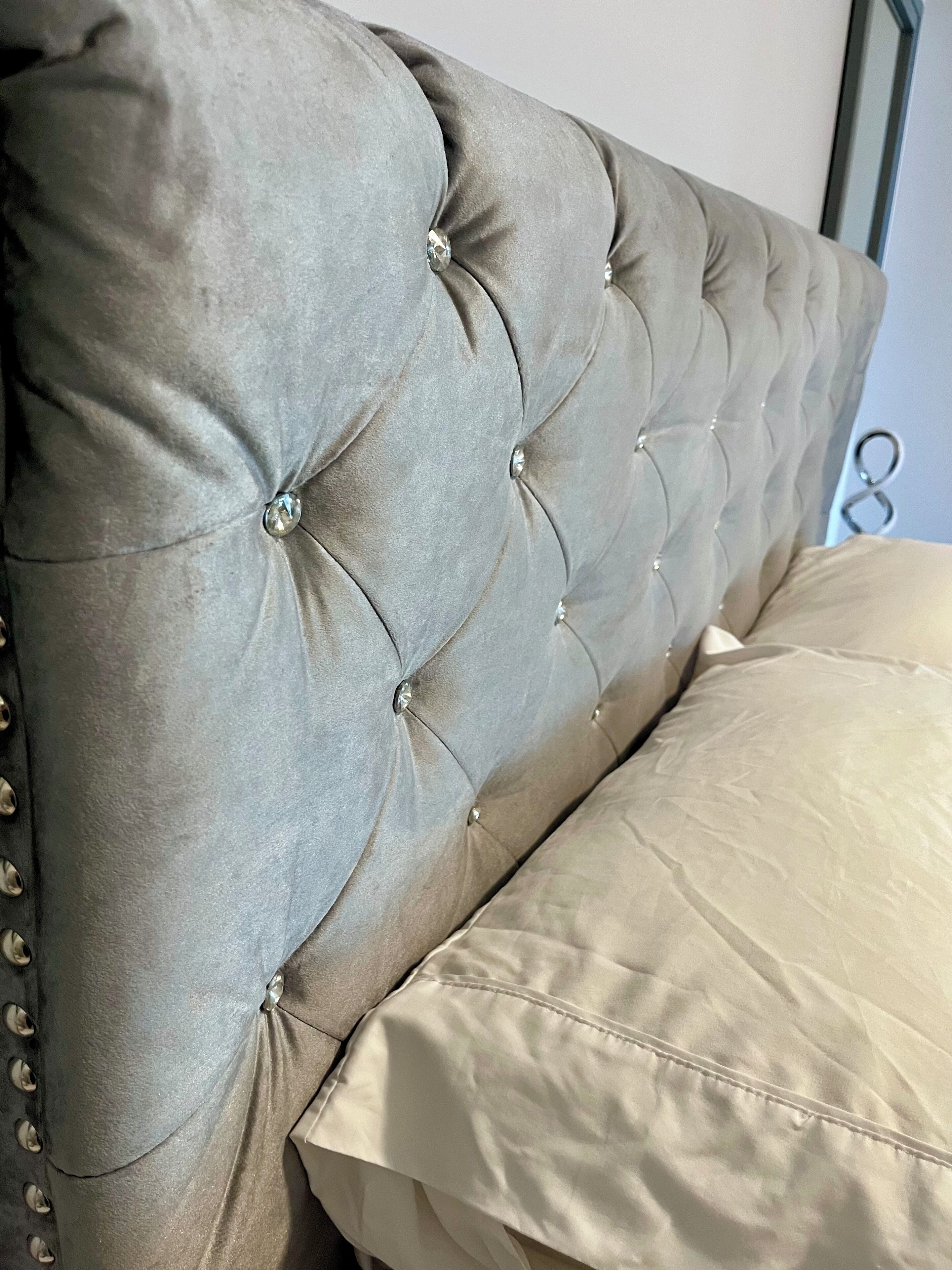 A tufted headboard with button detailing and a metal frame.