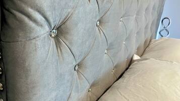 A tufted headboard with button detailing and a metal frame.