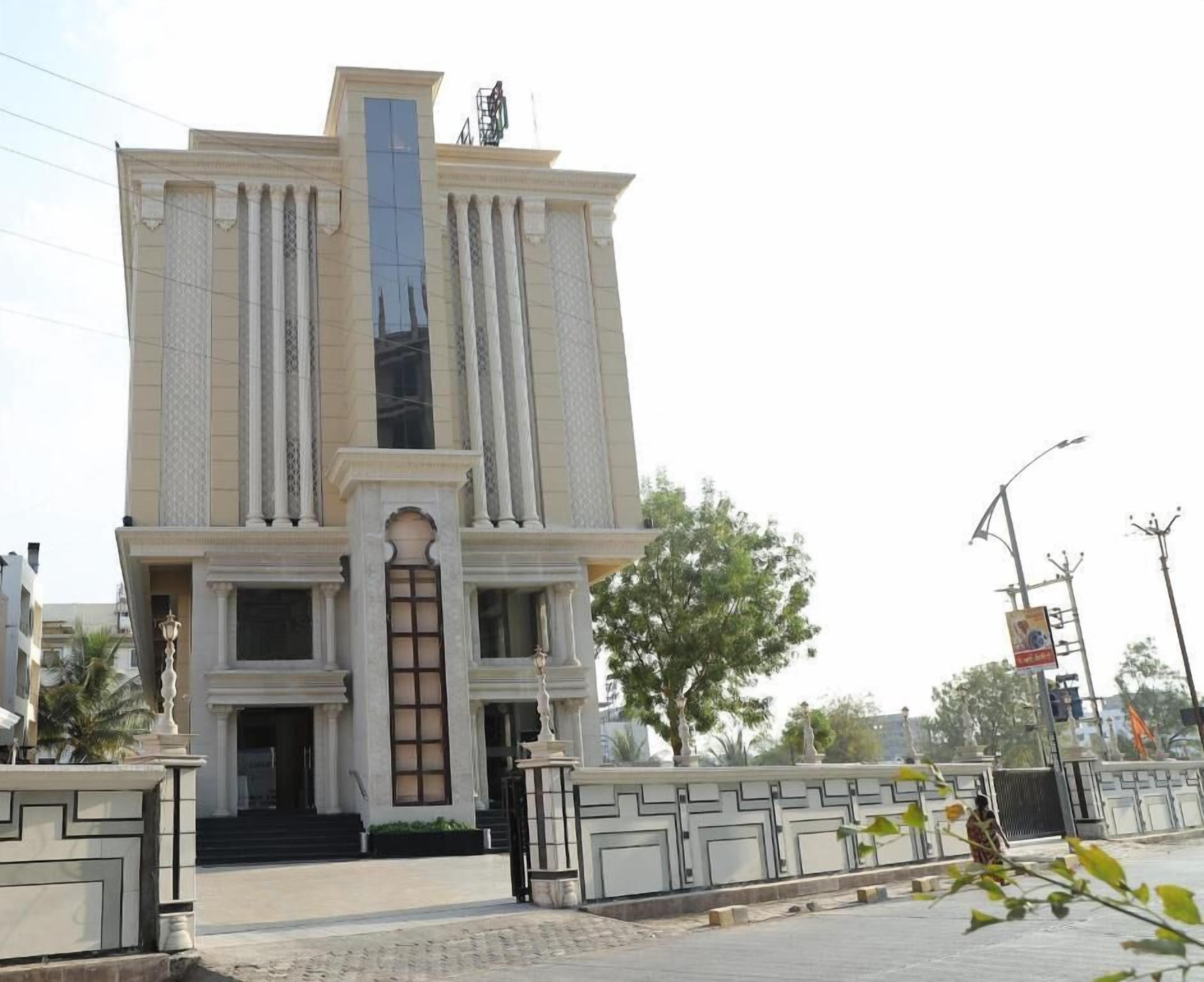Um edifício grande e clássico com uma entrada central, ladeada por colunas e fachada decorativa.