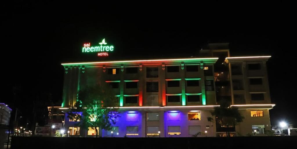 A hotel with a sign reading "neemtree HOTEL" and illuminated exterior lighting.