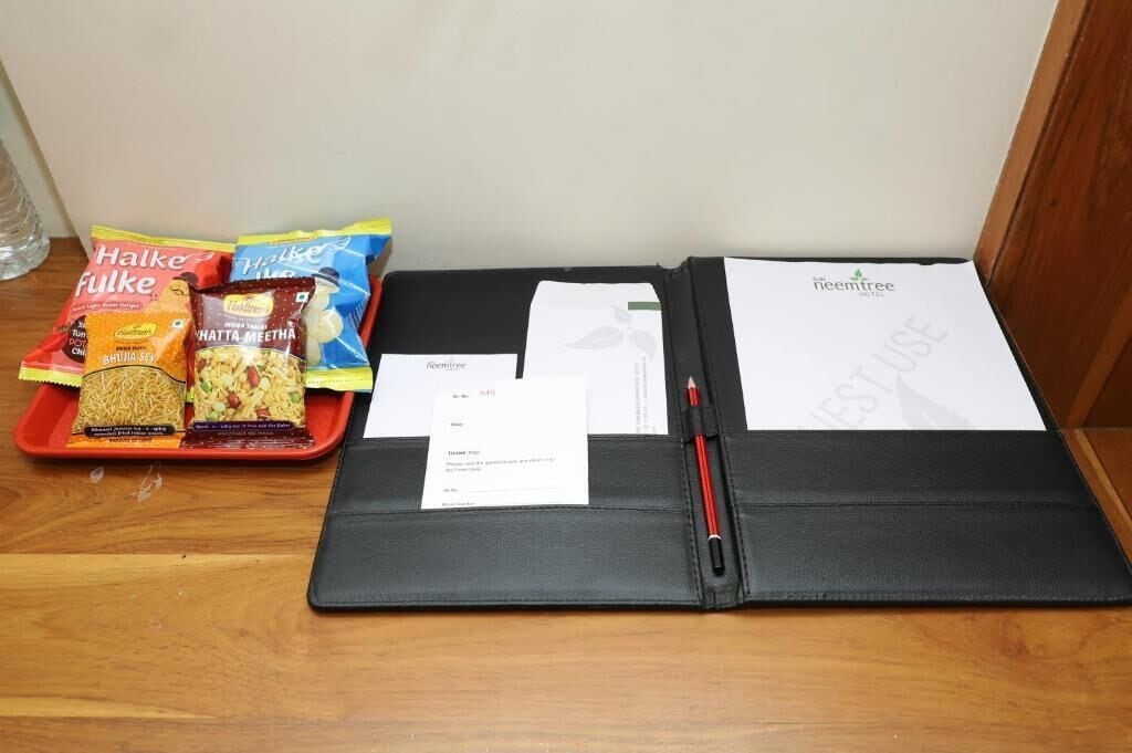 A black folder with a pen, a receipt, and a card on a wooden surface.