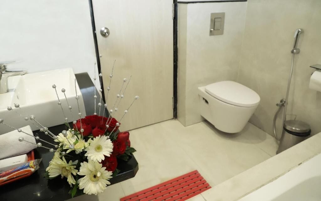 A bathroom with a toilet, sink, and shower.