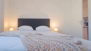 A neatly made bed with a white duvet and two pillows, flanked by two bedside lamps. - Rosemonde  Terrasse, calme  esprit village à La Chaume (Les Sables-d´Olonne)