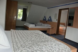 Un dormitorio con cama, mesita de noche, cómoda y espejo.