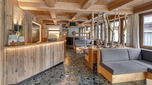 A wooden interior with a reception desk, seating area, and a fireplace. - Apartment in Fugen Near Spieljoch Ski Lift (Fuegen)