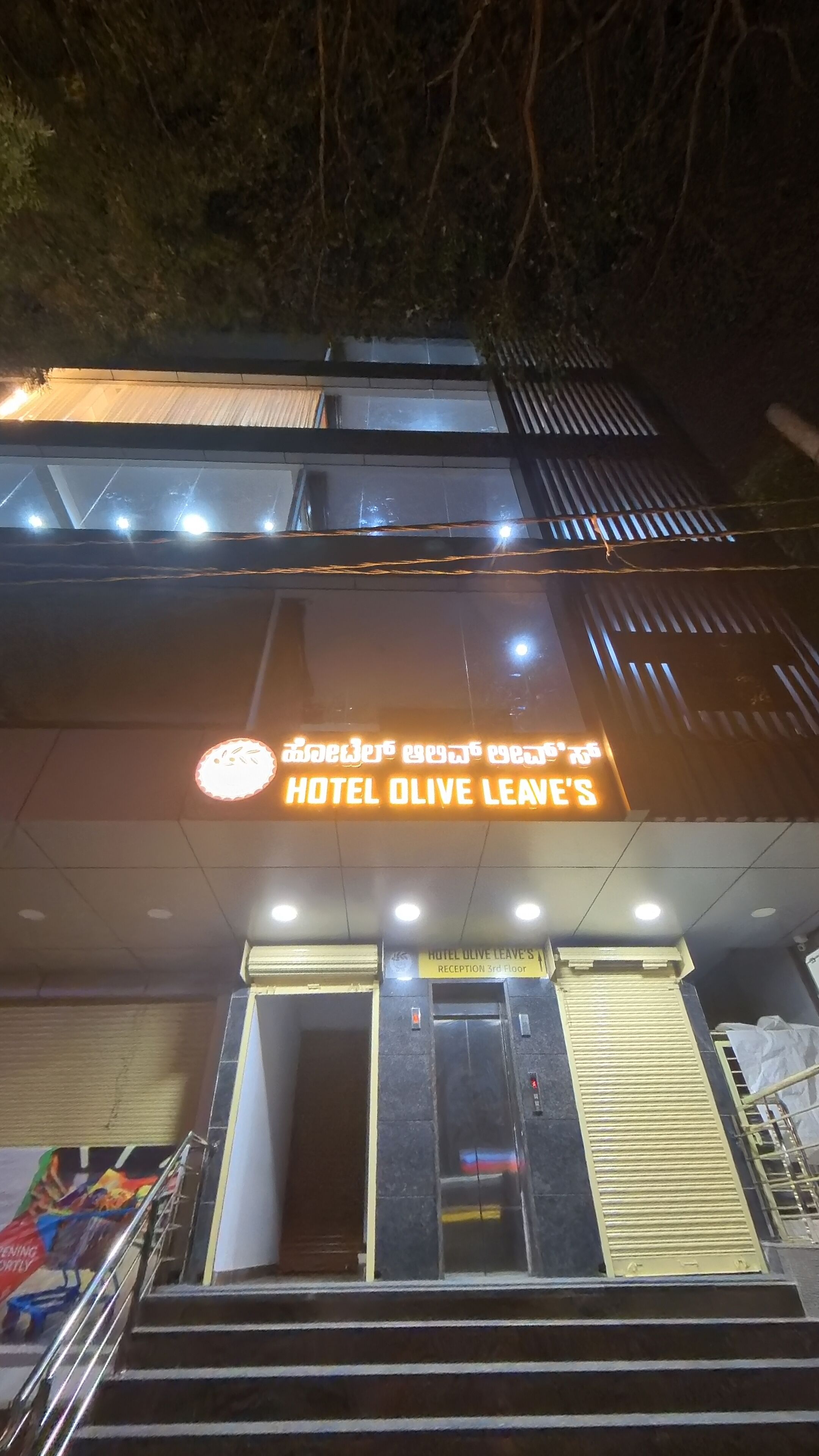 The exterior of Hotel Olive Leave's with a sign indicating the reception is on the 3rd floor.