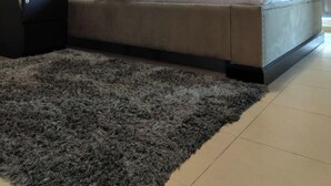 A bedroom with a bed, a nightstand, a lamp, and a large window with curtains. - Charming and Comfortable 1BR | Jumeirah Bay X1| JLT (Dubai)
