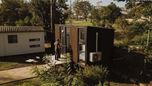 A small, modern structure with a sliding door, a window, and an air conditioning unit. - Monto Magic by Tiny Away (Monto)