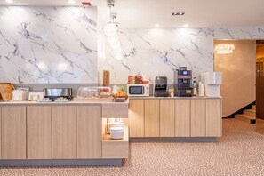 Un espace cuisine moderne avec des murs en marbre, des armoires en bois et un coin café.