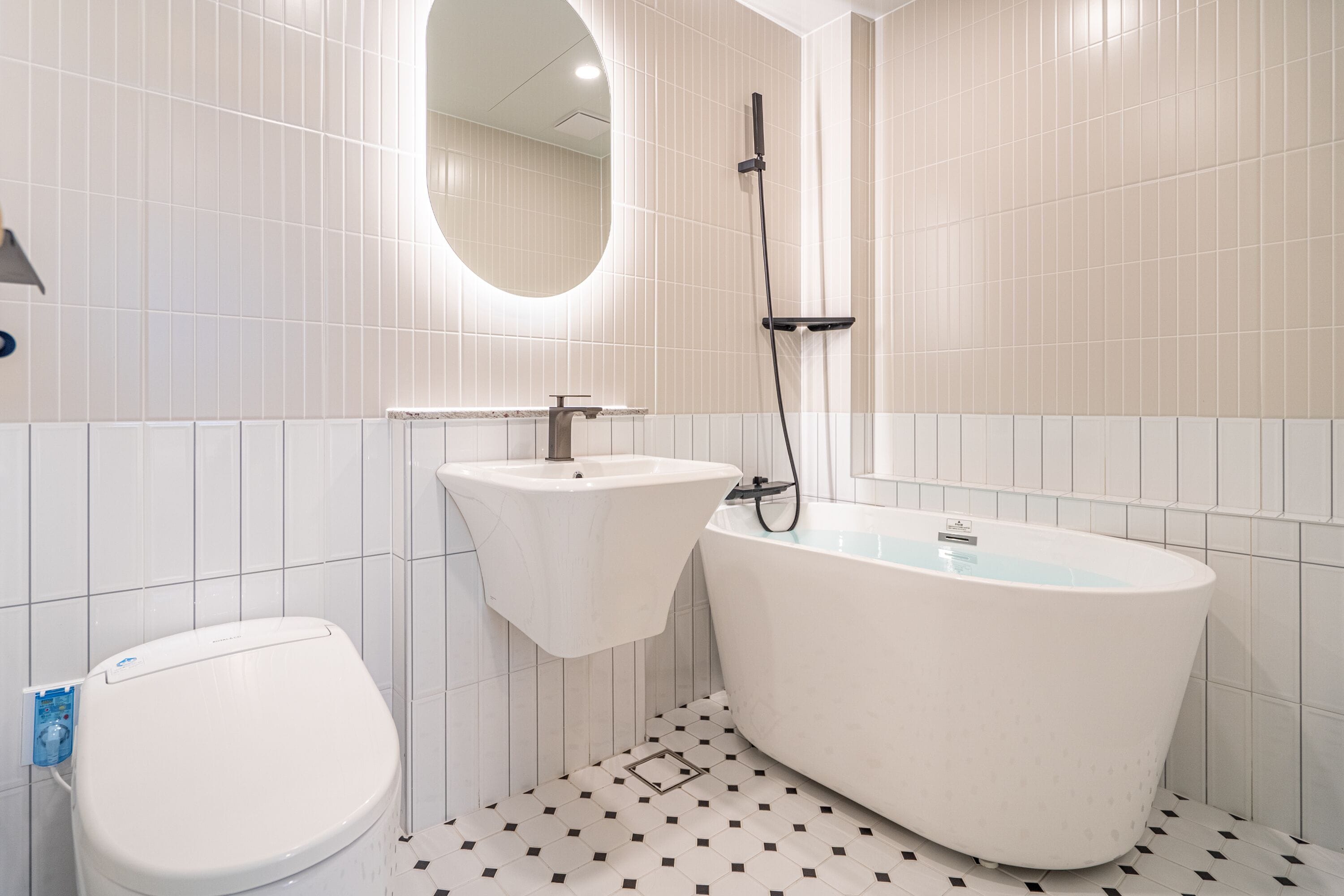 Un baño moderno con inodoro, lavamanos y bañera independiente.