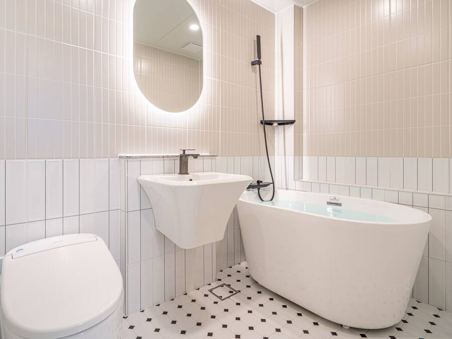 Un baño moderno con inodoro, lavamanos y bañera independiente.