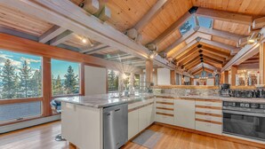 Una cocina moderna con una isla central, lavavajillas integrado y un horno grande.