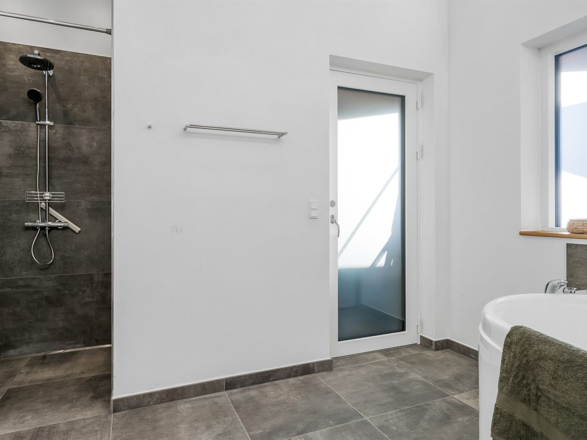 A modern bathroom with a shower, a glass door, and a bathtub.