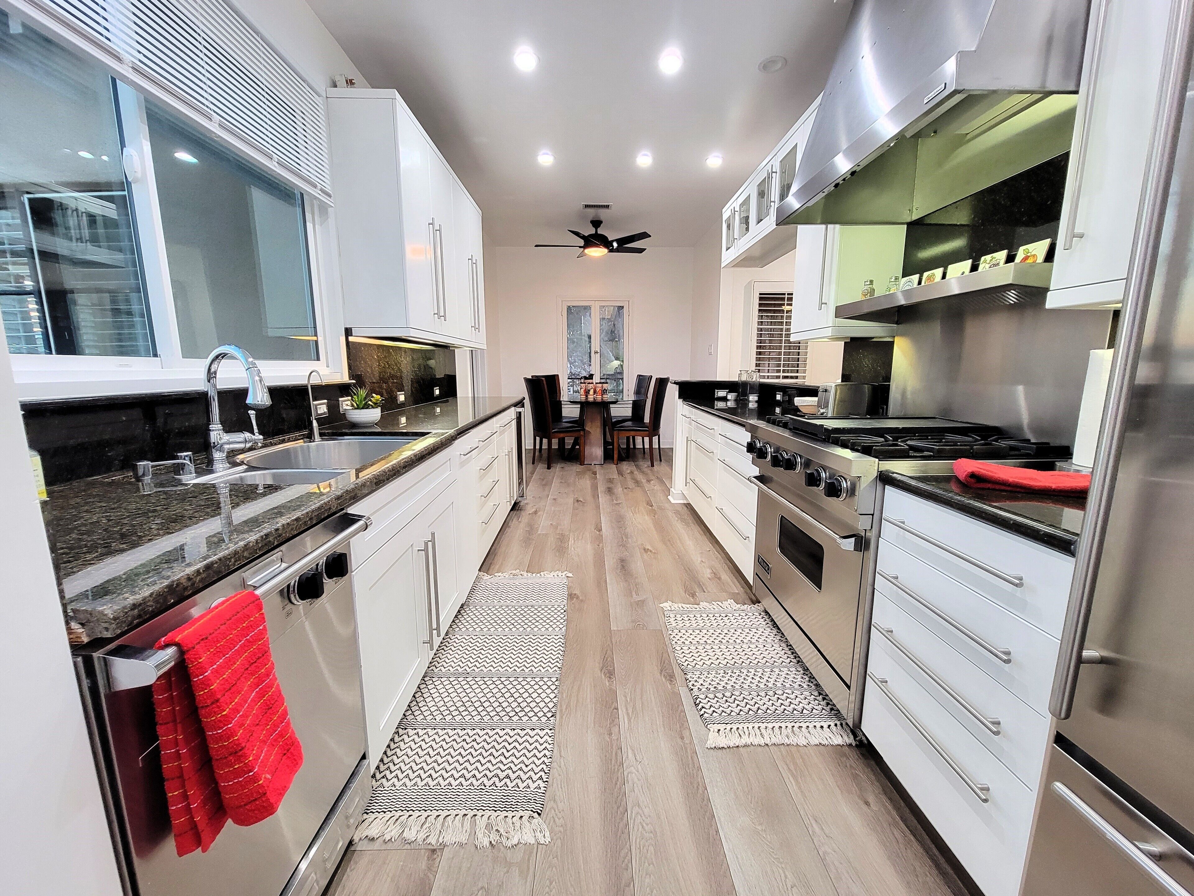 Una cocina moderna con electrodomésticos de acero inoxidable, una isla central y un comedor con sillas.
