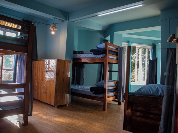 A bunk bed room with a wooden wardrobe and a window with curtains. - Hills Tale Backpackers Hostel (Kalimpong)
