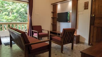 Deluxe apartman, erkély, kilátással a medencére | Nappalirész | LED-tévé