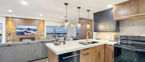 A modern kitchen with a built-in island, stainless steel appliances, and a large window overlooking a scenic view.