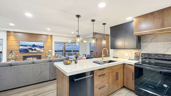 A modern kitchen with a built-in island, stainless steel appliances, and a large window overlooking a scenic view.
