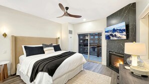 A modern bedroom with a bed, a ceiling fan, a fireplace, and a balcony with a mountain view. - Renovated Presidential Suite•3 Fireplaces•Private Hot Tub w/Views•Resort Ameniti (Park City)