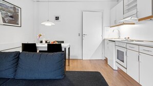 Una cocina moderna con gabinetes blancos, horno empotrado y encimera.