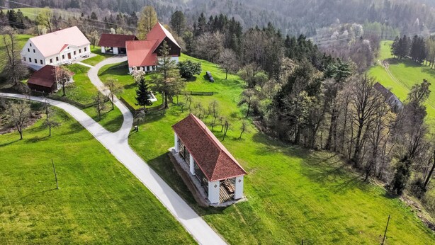 Vista aérea de una propiedad rural con una casa principal, un granero y una pequeña casa de huéspedes.