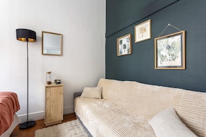 Ein Schlafzimmer mit Bett, Nachttisch, Stehlampe und Wandbildern.