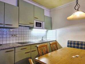 Enjoy meals in this cozy kitchen area with a dining table and chairs.