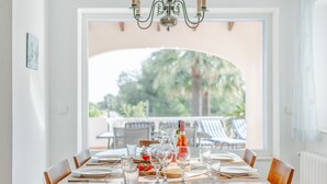 Mesa de comedor preparada para seis personas con vistas al exterior.