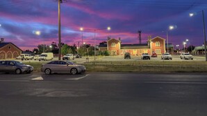 A parking lot with several cars and a building with a red brick facade.