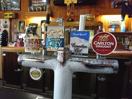 Grifo de bar con varias opciones de cerveza, incluyendo marcas como Great Northern Brewing Co., Carlton Dry y Bulmers.