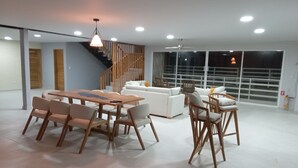 A spacious living area with a dining table, sofas, and a staircase. - STEPHENS HOUSE, 7 color ocean front San Andres Islands. (San Andrés y Providencia)