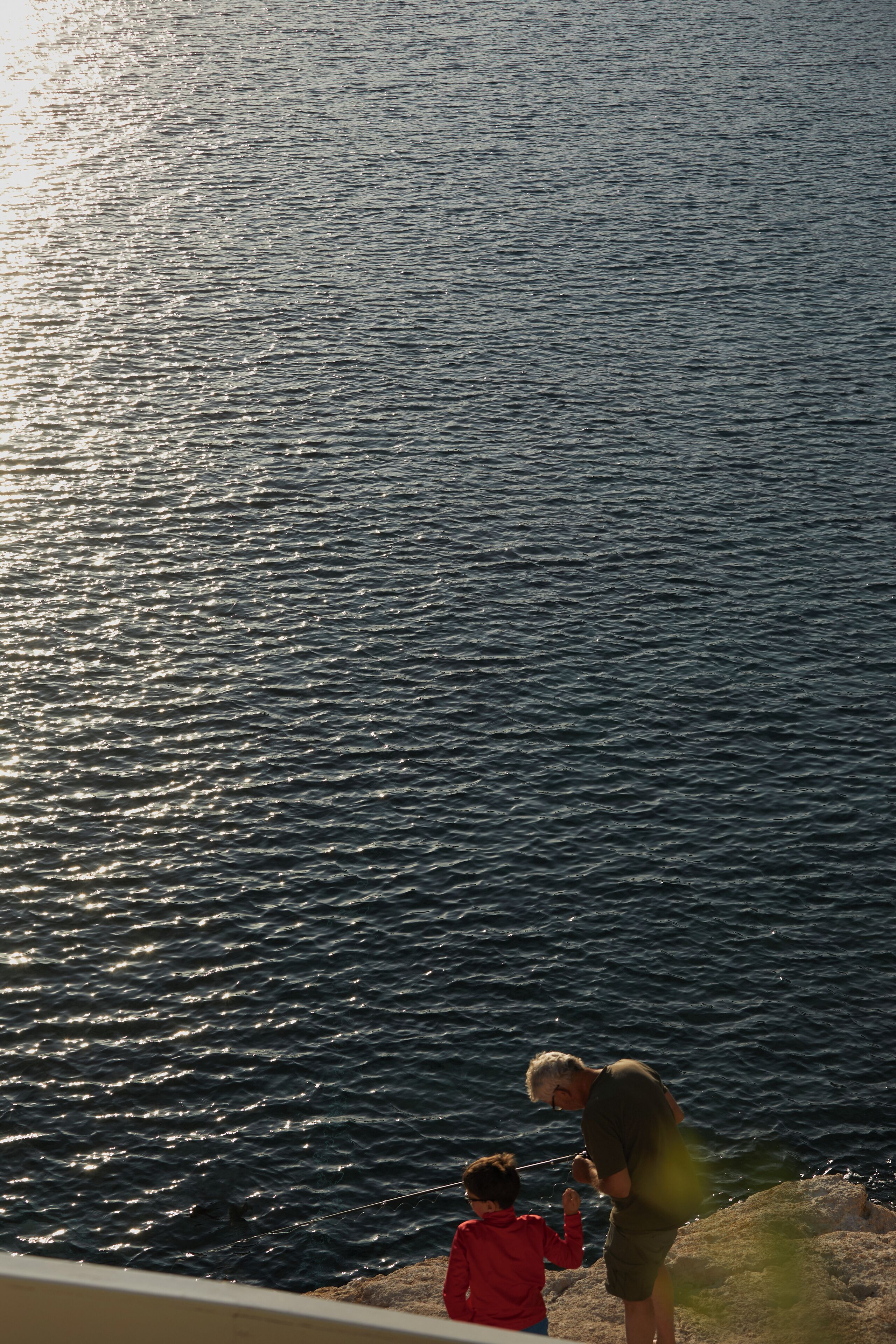 A view of a body of water with a person fishing.