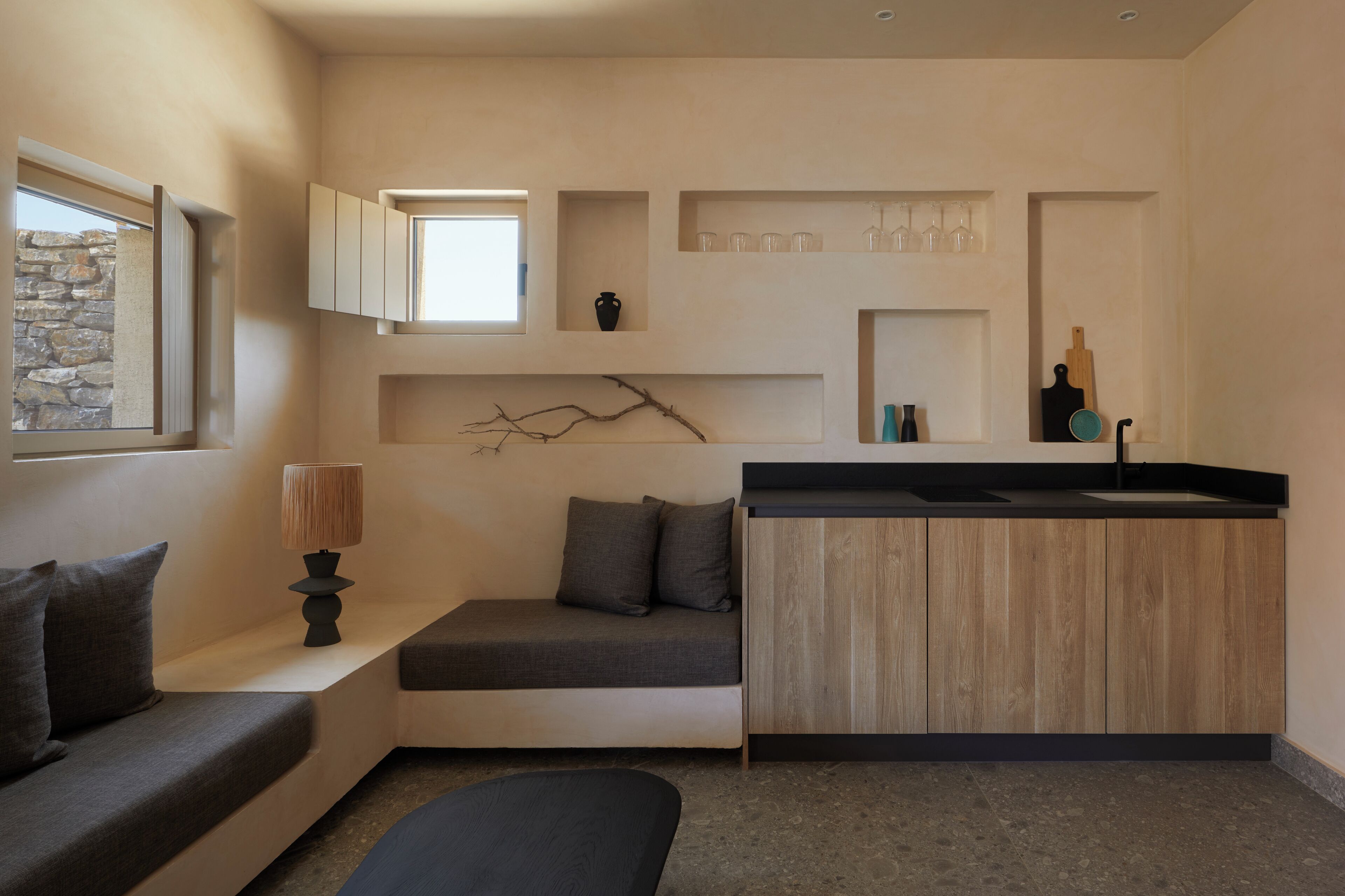 A compact kitchen with built-in cabinets, a countertop, and a window.