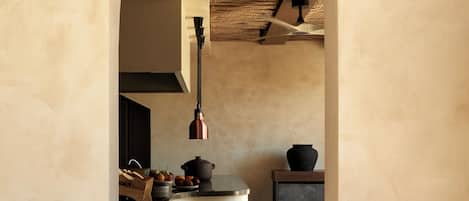 A kitchen with a central island, a hanging light fixture, and a wooden chair.