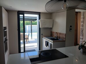 Enjoy cooking in this well-lit kitchen with oven, microwave, and induction cooktop.
