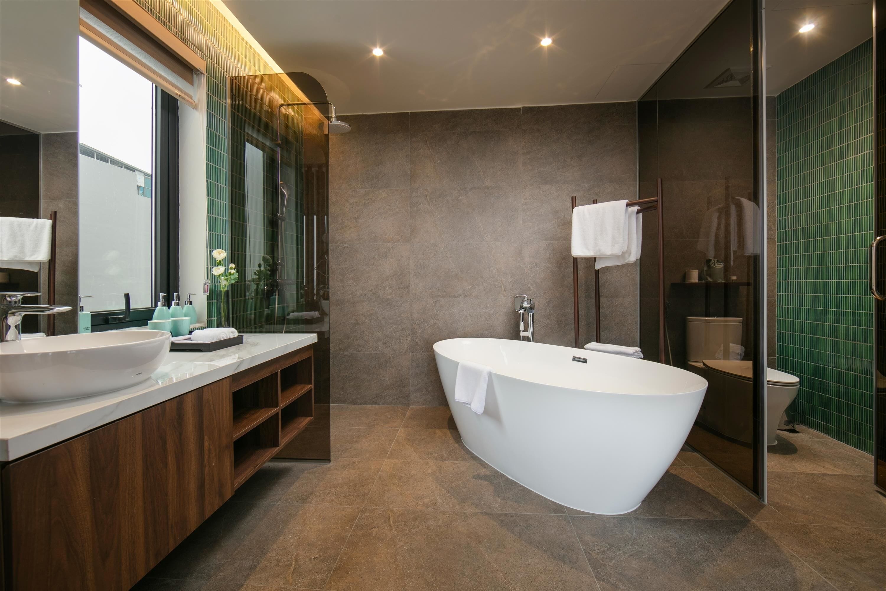 A modern bathroom with a freestanding bathtub, a large mirror, and a vanity with a sink.