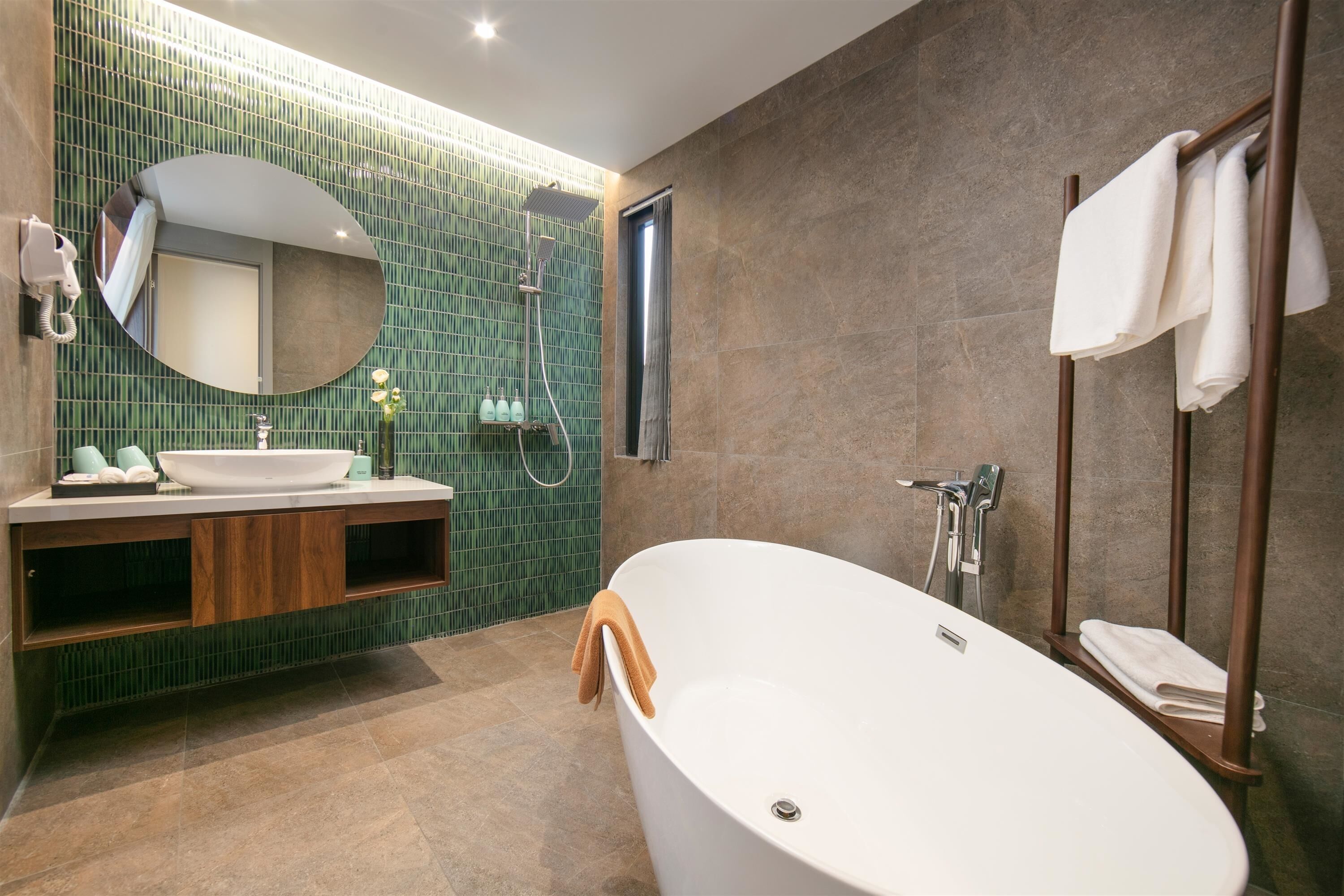A modern bathroom with a freestanding bathtub, a vanity with a mirror, and a shower area.