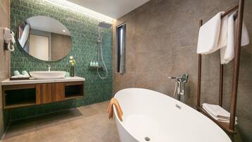 A modern bathroom with a freestanding bathtub, a vanity with a mirror, and a shower area.
