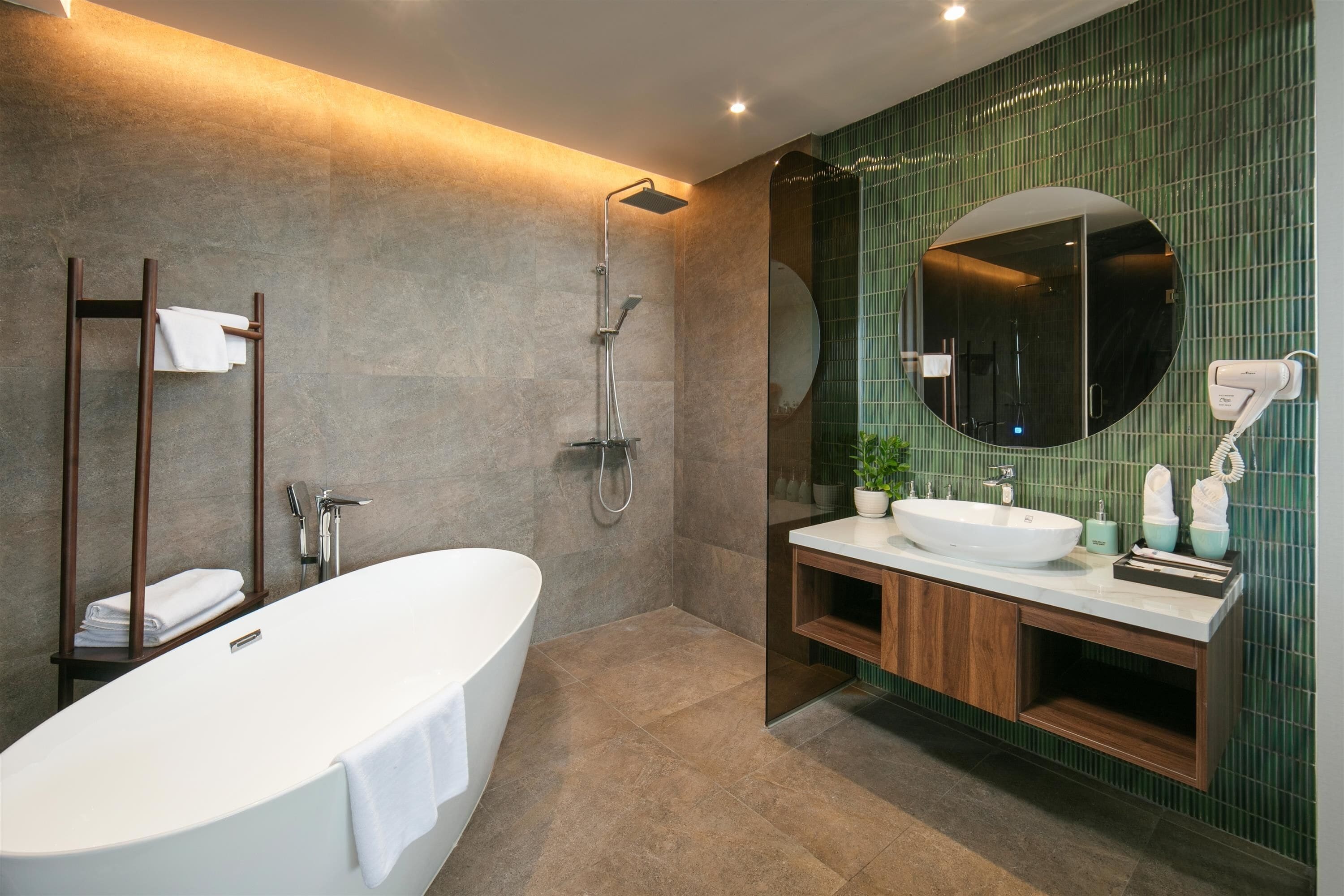 Ein modernes Badezimmer mit freistehender Badewanne, einer bodenebenen Dusche und einem Waschtisch mit großem Spiegel.