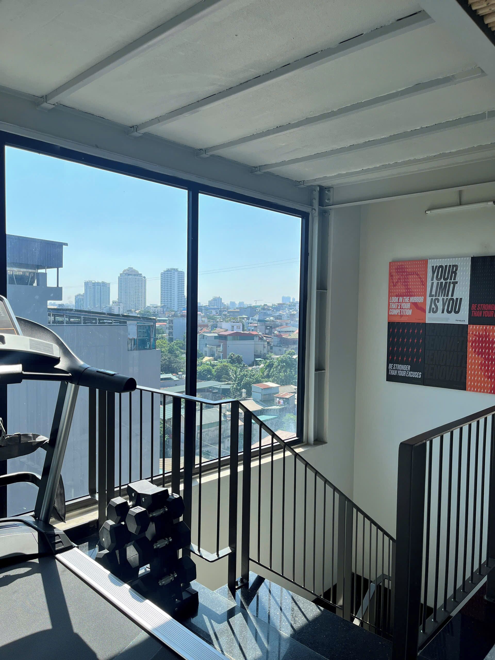 A gym with exercise equipment, a treadmill, and dumbbells.