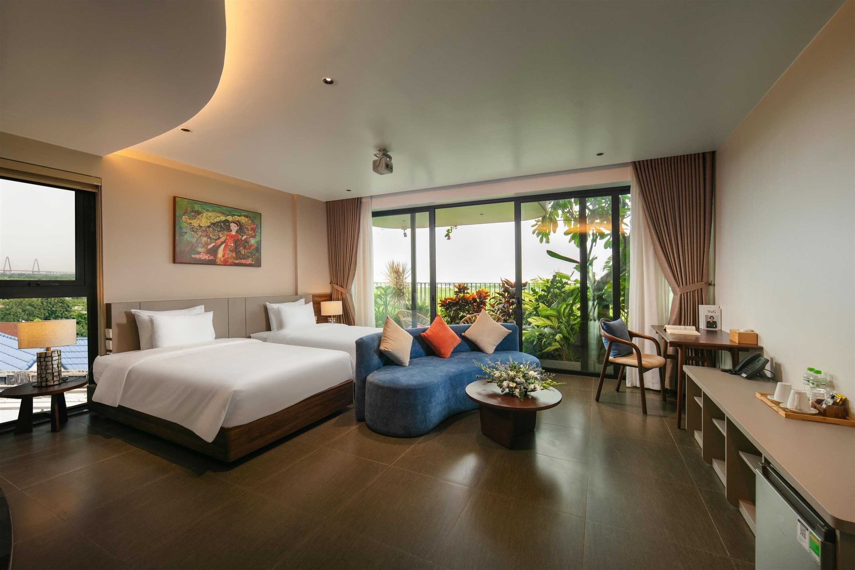 Een moderne hotelkamer met een groot bed, een sofa, een zithoek en een balkon met uitzicht.