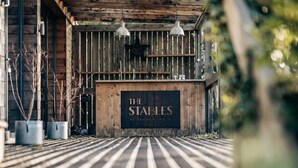 Eine Holztreppe führt zu einem Schild mit der Aufschrift 'The Stables'.