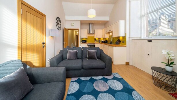 A compact living space with a sofa set, a dining area, and a kitchen.